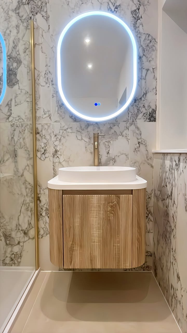 Oak-look floating vanity, vessel basin and illuminated mirror in the completed Bramhall bathroom