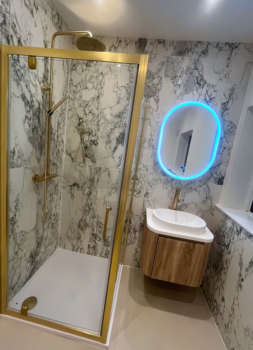 Walk-in shower and coordinating warm metal shower fittings in the Bramhall bathroom